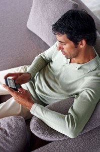Man sitting on a couch, texting
