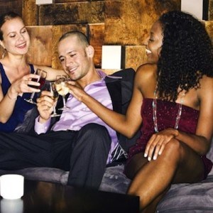 Guy enjoying drinks with two women