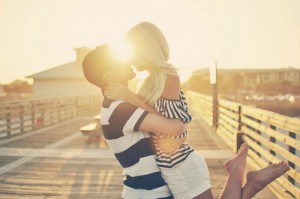 Couple embracing during sunset on pier.