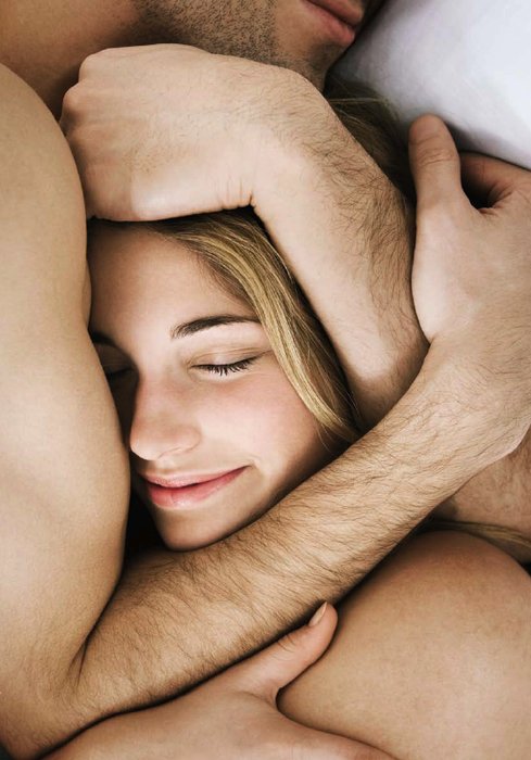 Man and woman cuddling in bed