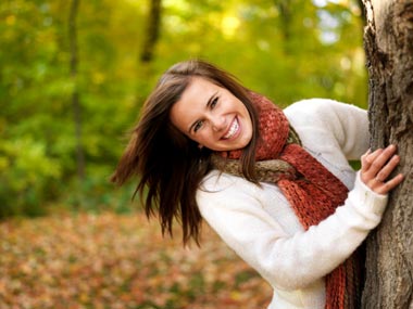 Playful woman behind a tree