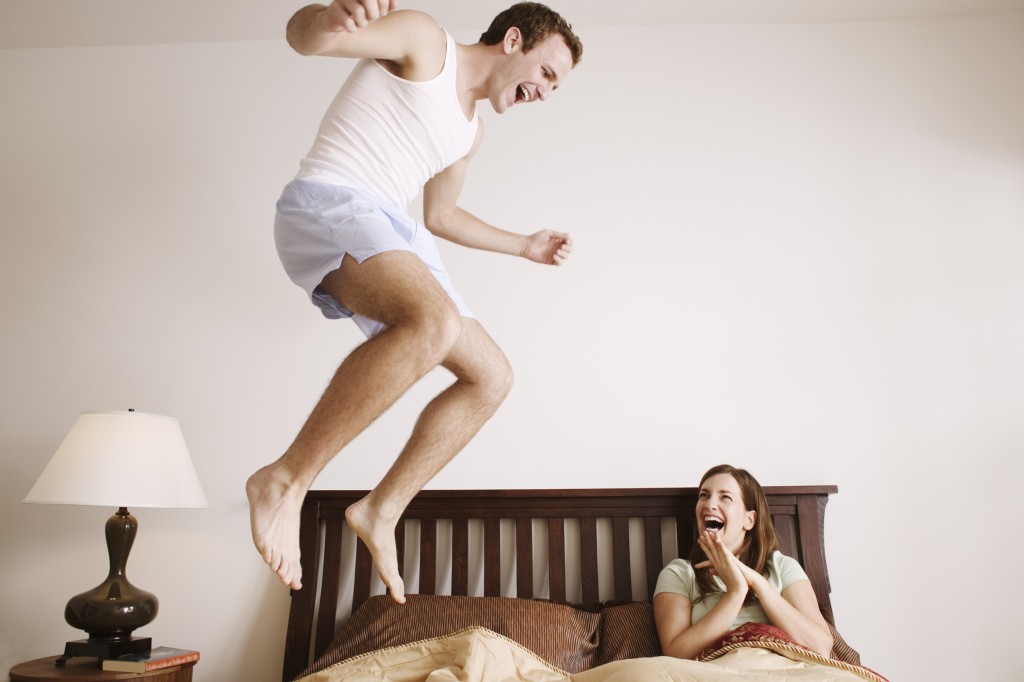 Man jumping on his bed