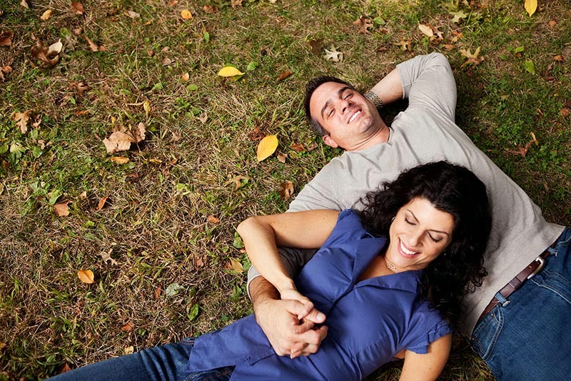 Happy couple snuggling in the grass