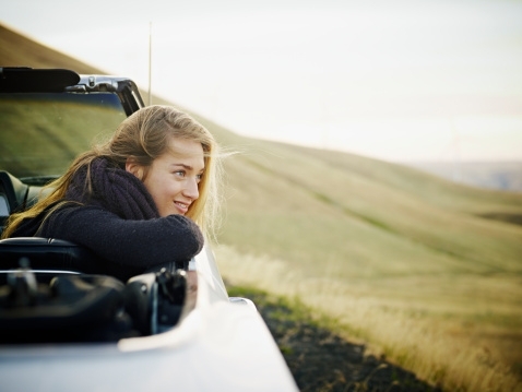 Happy woman in back of convertible