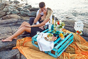 Couple having picnic beside the ocean.