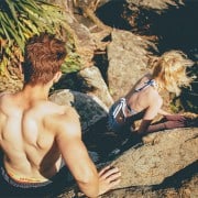 Couple climbing in swim suits.