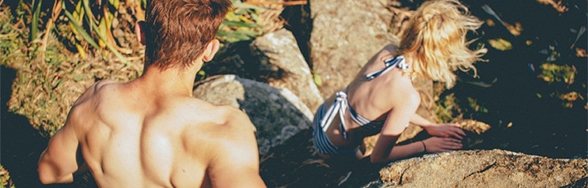 Couple climbing in swim suits.