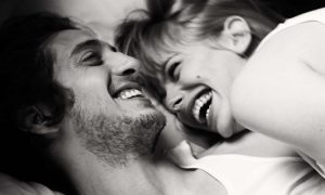Couple laughing in bed together