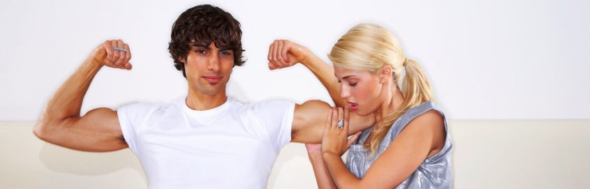 woman holding a man's flexed bisep at that table