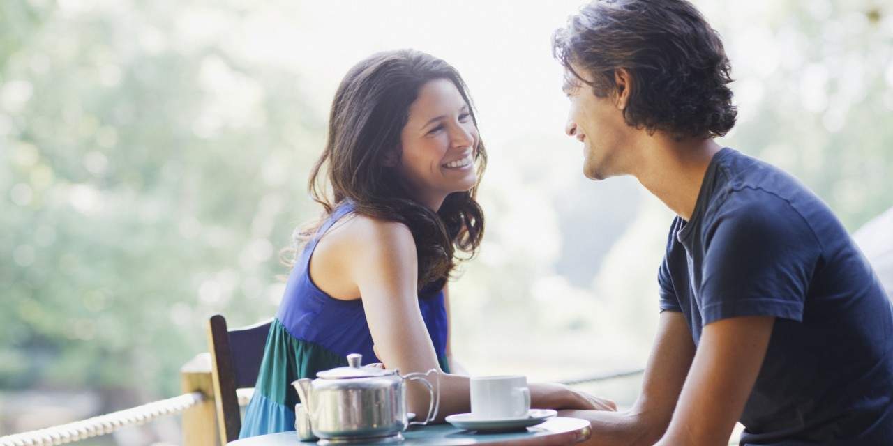 couple laughing and sitting at a table together 