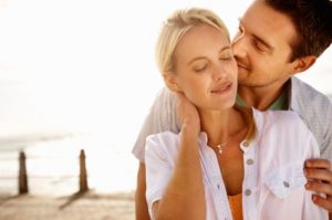 young couple. man behind the woman kissing her cheek 