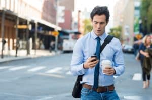 man texting on street