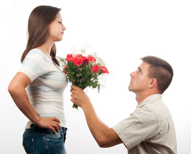 man grovelling on knees to woman