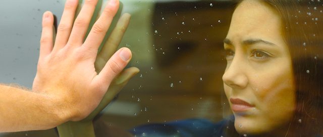 couple-hold-hands-through-window