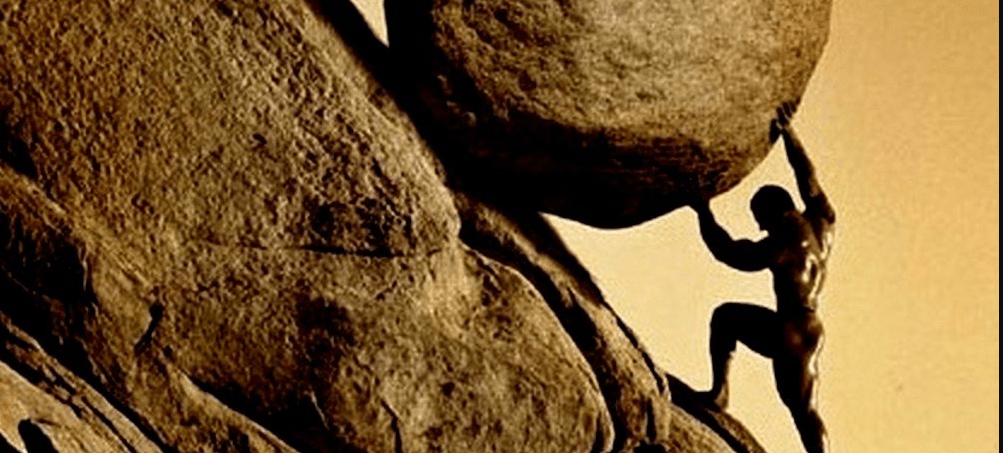 man pushing boulder up hill